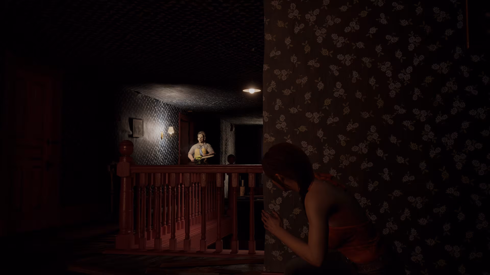 Em The Texas Chain Saw Massacre, dentro da casa, Julie está escondida contra uma parede com papel de parede floral, enquanto um homem com uma motosserra (Leatherface) se aproxima através do corredor escuro e mal iluminado.